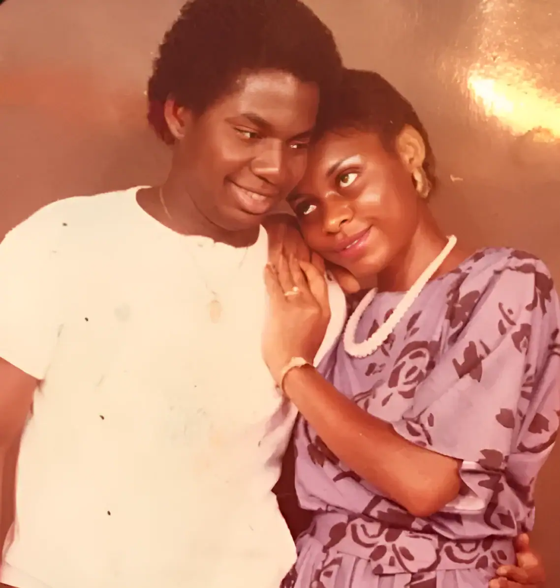 Couple embracing, smiling, in a warm indoor setting.